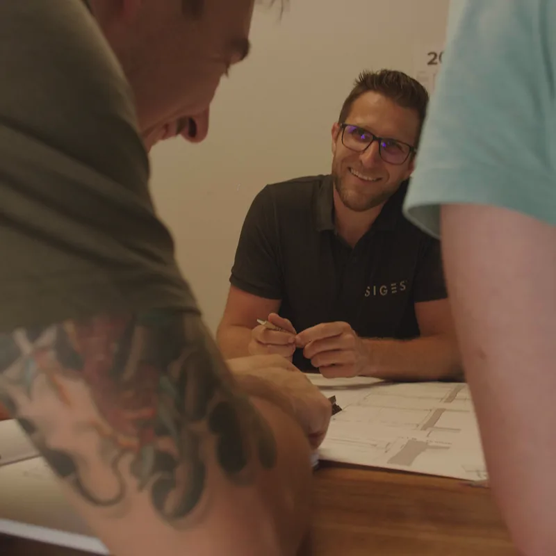 Personen die vor einem Plan sitzen und lachen