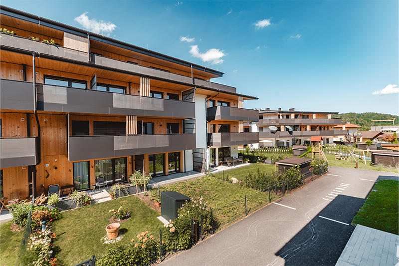 Wohnanlage Wohnen am Sagergut in Thalgau mit moderner Holzfassade, großzügigen Balkonen und begrünten Außenanlagen.