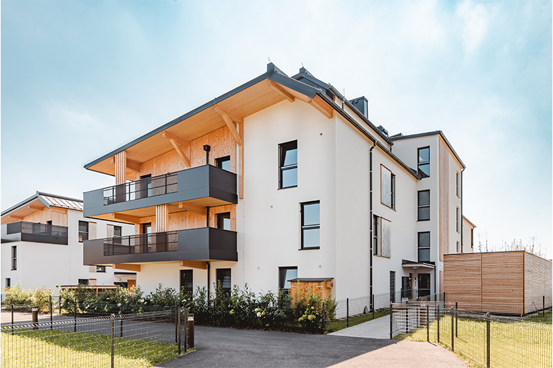 PEFC-zertifizierte Holzbauten beim Wohnprojekt Wohnen am Sägegut in Thalgau mit modernen Balkonen und Holzdetails.